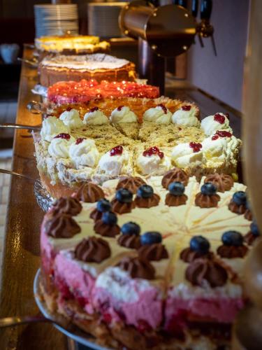 a table topped with several cakes with blueberries on top at Hotel Kaiserhof in Medebach
