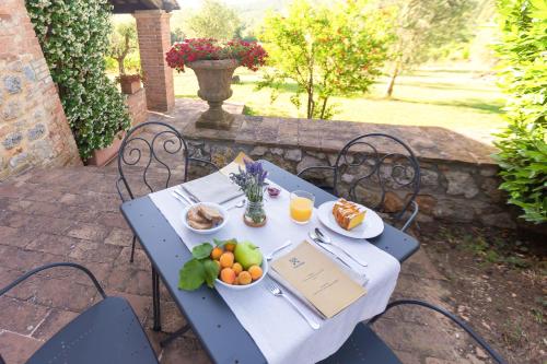 a blue table with a plate of fruit on it at Borgo d&eacute; Brandi in Monteriggioni