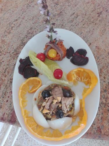 a plate of food with eggs and fruit on it at Casa Mia in Ouled Kacem