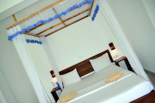 a bedroom with a white bed with a canopy at The Chillout Ella in Ella