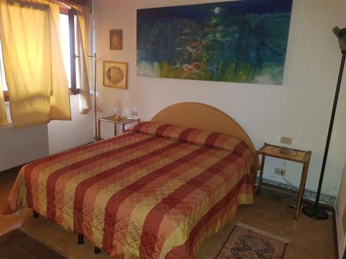 1 dormitorio con 1 cama y una pintura en la pared en AL BORGO ANTICO Ristorante con camere, en bedizzol