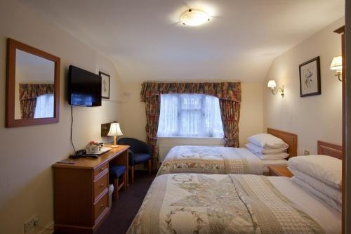 a hotel room with two beds and a desk at Clifton Bridge Hotel in York