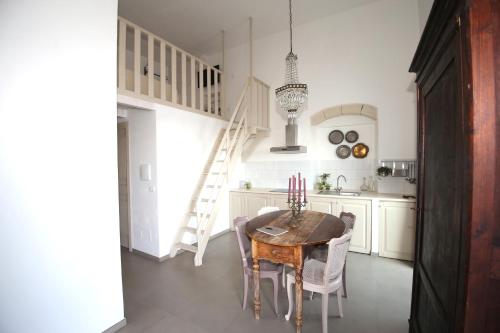 a kitchen with a table with chairs and a staircase at Don Alfredo in Taranto