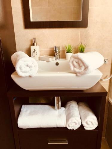 a bathroom with a sink and towels on a shelf at El Rincón Azul Benicasim centro in Benicàssim