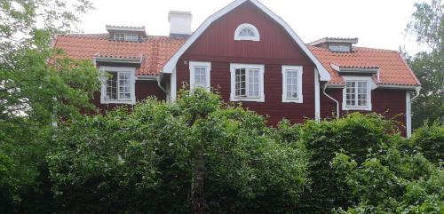 a red house with a red roof on top of trees at Stockholm B&B Cottage in Nacka