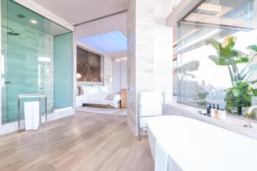 a bathroom with a large window and a bedroom at Ellerman House in Cape Town