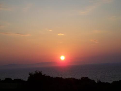 a sunset over the ocean with the sun in the sky at Panorama in Skafidia
