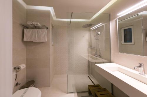 a bathroom with a shower and a sink and a toilet at Bueno Hotel in Platanes