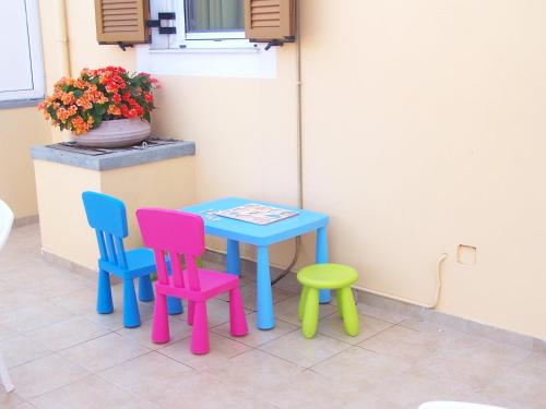 a table and four chairs sitting next to a wall at Villa Romantza in Fiskardho