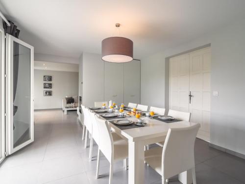une salle à manger blanche avec une grande table et des chaises blanches dans l'établissement Villa in Occitanie with Private Pool, à Saint-Geniès-de-Fontedit