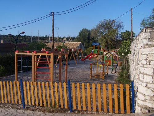 a playground behind a fence with a play area at Villa Romantza in Fiskardho