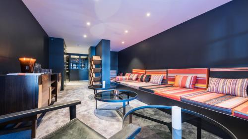 a waiting area with couches and tables in a room at Fahrenheit Seven Courchevel in Courchevel