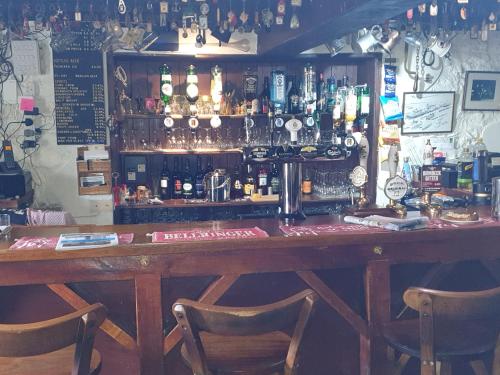 a bar with two chairs in front of a counter at the old red lion in Bruton