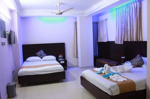 Giường trong phòng chung tại Royal Palm Hotel