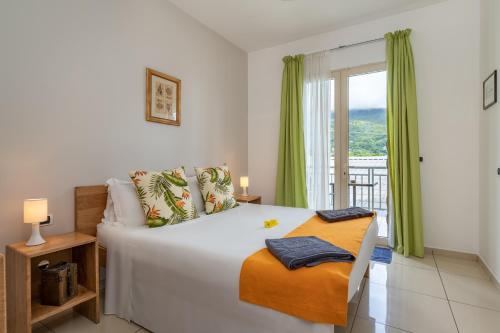 1 dormitorio con 1 cama grande y balcón en Villa Roscia, en Beau Vallon
