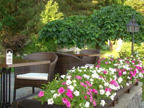 a patio with tables and chairs and flowers at Panoramahaus Steiner in Mariapfarr