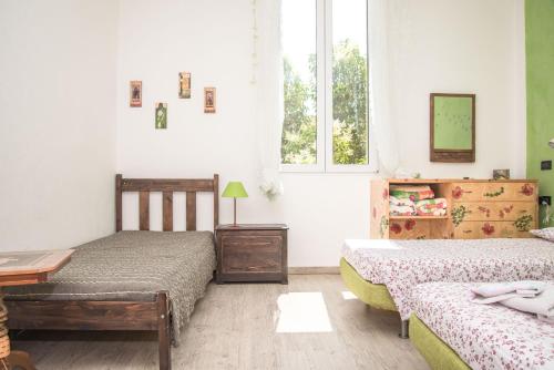 a bedroom with two beds and a table and two windows at A Casa Fachin Room & Breakfast in Bologna
