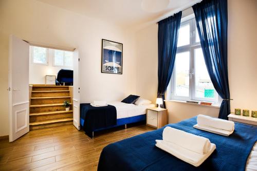 1 dormitorio con 2 camas y escalera en Monte Cassino Apartments, en Sopot