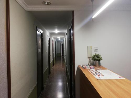 a hallway with a desk and a long corridor at Hostal Milmarcos in Zaragoza