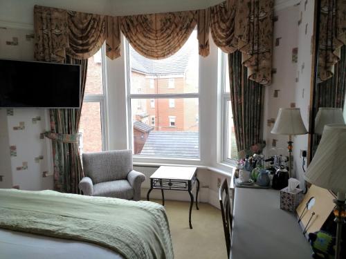 a bedroom with a bed and a large window at Bay Tree House Southport, United Kingdom in Southport