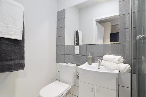 a white bathroom with a toilet and a sink at Salsa Hostel Premium in Łódź