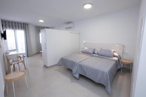 Un dormitorio con una cama y una mesa y sillas. en Apartamentos Mombasa 1 Planta, en Nerja