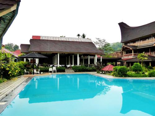 a swimming pool in front of a building at Toraja Torsina Hotel in Rantepao