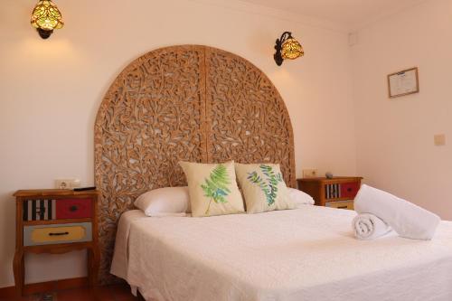 a bedroom with a large bed with a wooden headboard at Hotel Casa Día y Noche in Calpe