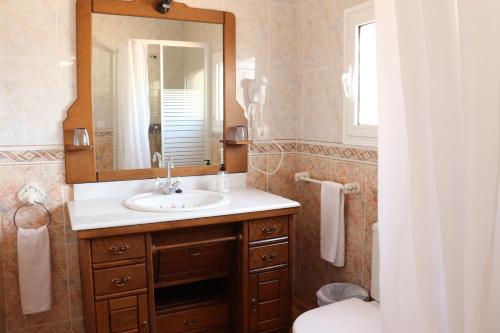 a bathroom with a sink and a mirror and a toilet at Hotel Casa Día y Noche in Calpe