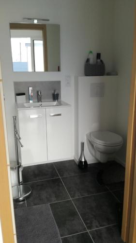 a bathroom with a toilet and a sink at La casita de Vanessa in Changé