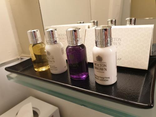 drei Flaschen auf einem Regal in einem Badezimmer in der Unterkunft Aria Hotel Prague in Prag