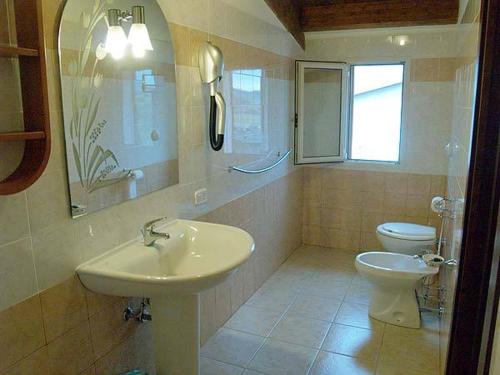 a bathroom with a sink and a toilet at Agriturismo Le Frasche in Alberese