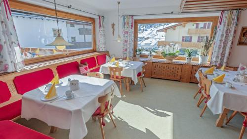 a restaurant with tables and chairs and a window at Haus Schrofenstein in Lech am Arlberg