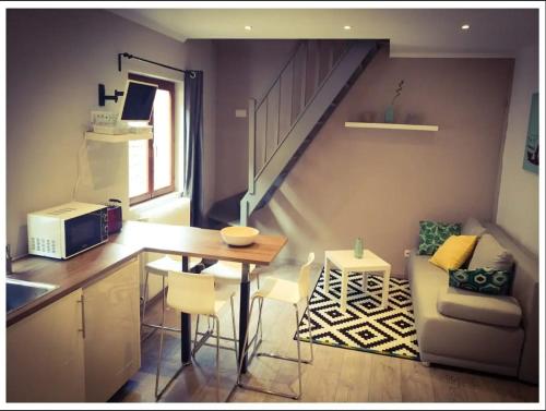 uma pequena cozinha com uma mesa e uma escada em Chez SANDRA em Obernai