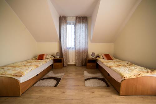 two beds in a room with a window at Agroturystyka Nowa Wólka in Łęczna