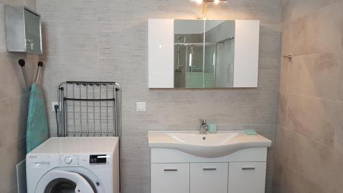 a bathroom with a washing machine and a sink at Tanyas Cozy House in Kamilari