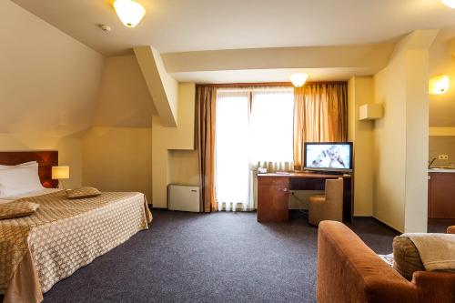a hotel room with a bed and a television at Sofia Place Hotel by HMG in Sofia