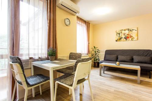 a living room with a table and chairs and a couch at Sofia Place Hotel by HMG in Sofia