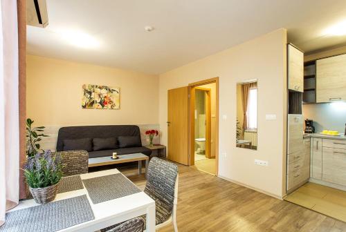 a living room with a table and a couch at Sofia Place Hotel by HMG in Sofia