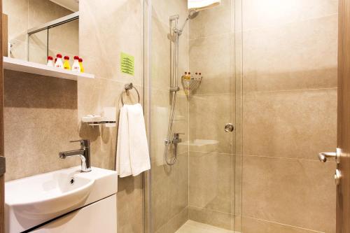 a bathroom with a shower and a sink at Sofia Place Hotel by HMG in Sofia