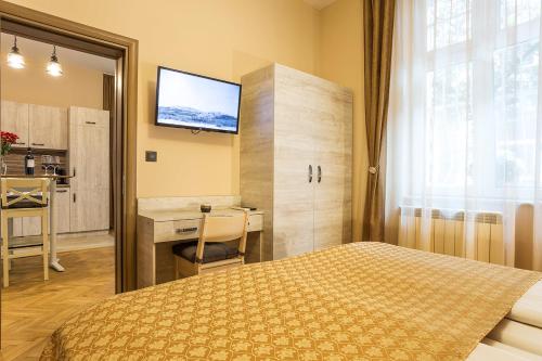 a bedroom with a bed and a desk and a television at Sofia Place Hotel by HMG in Sofia