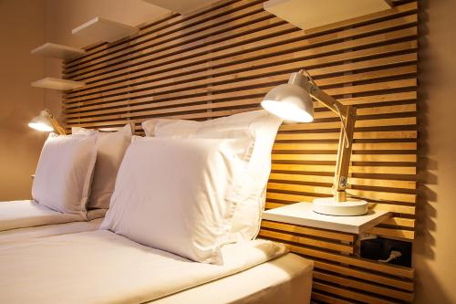 a bedroom with a bed with white pillows and a lamp at Sofia Place Hotel by HMG in Sofia