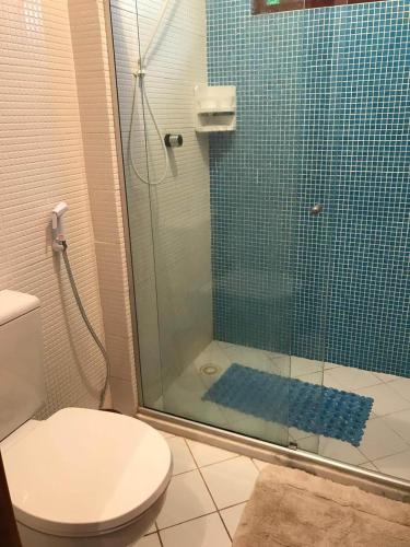 a bathroom with a toilet and a glass shower at Paz & Diversão Praia Do Forte in Praia do Forte