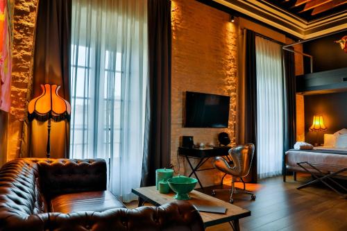 a living room with a leather couch and a bed at Hotel Lobby in Seville