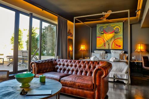 a living room with a leather couch and a bed at Hotel Lobby in Seville