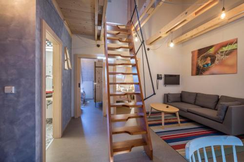 a room with a couch and a spiral staircase at tvrz KRASSA in Osečná