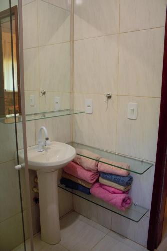 a bathroom with a sink and a mirror and towels at Casa em Pipa 2 quartos in Pipa