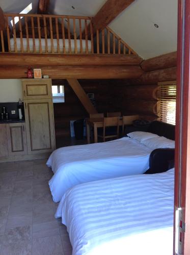 two beds in a room with wooden ceilings at lyne view, log cabin in Carlisle