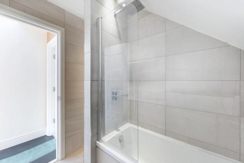 een badkamer met een douche en een glazen deur bij Stunning Luminous Penthouse/ 2Beds 2Baths in Bournemouth