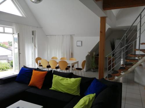a living room with a black couch with colorful pillows at Ferienimspessart OG in Bad Soden-Salmünster